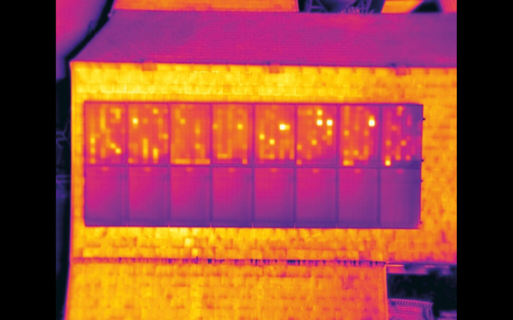 Despite their low resolution, small micro-bolometer radiometric cameras reveal the chessboard pattern of overheated cells in a string of solar panels