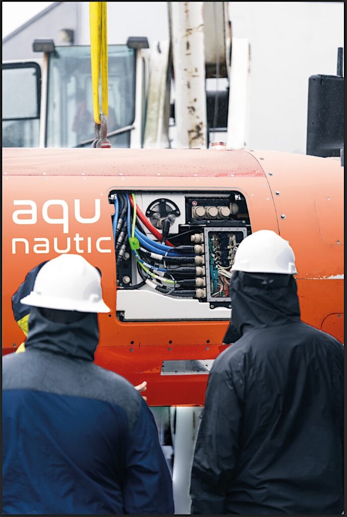 Technicians inspects cabling through the hull hatch aperture. Packaging he computing, sensing and manipulation systems plus the high-capacity battery and propulsion components in the volume available was a major design challange