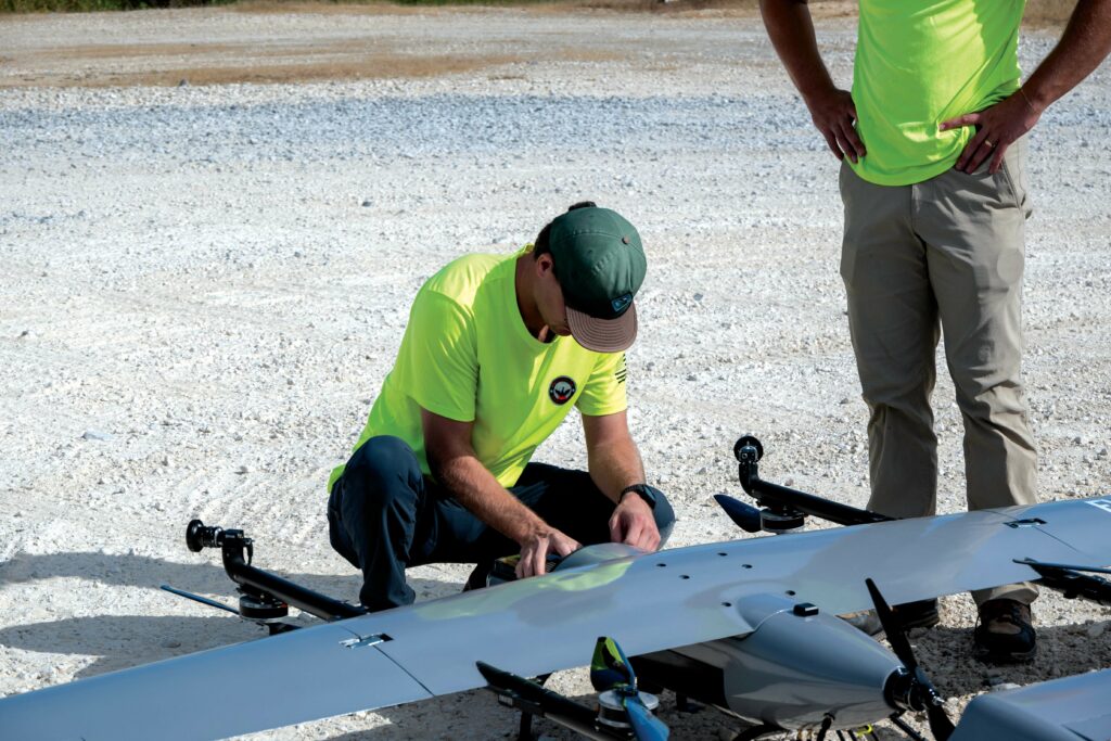 PAU operators check over the E455 between flights. The fuselage houses systems including the battery, payload bay and cruise motor