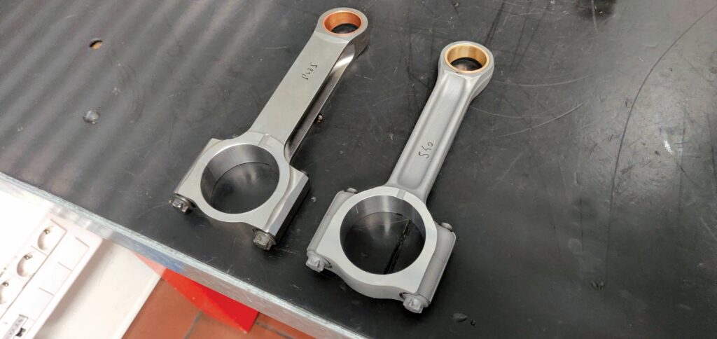Since last being featured, the 100 TD2’s steel con rods have gone from being CNC-machined H-beam parts (left) to forged I-beams (right), reducing their cost and time to manufacture